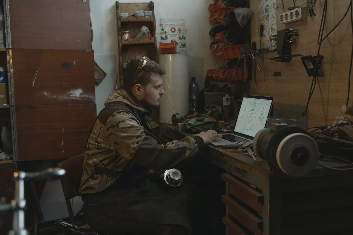 Artisan qui fait ses comptes sur ordinateur dans son atelier