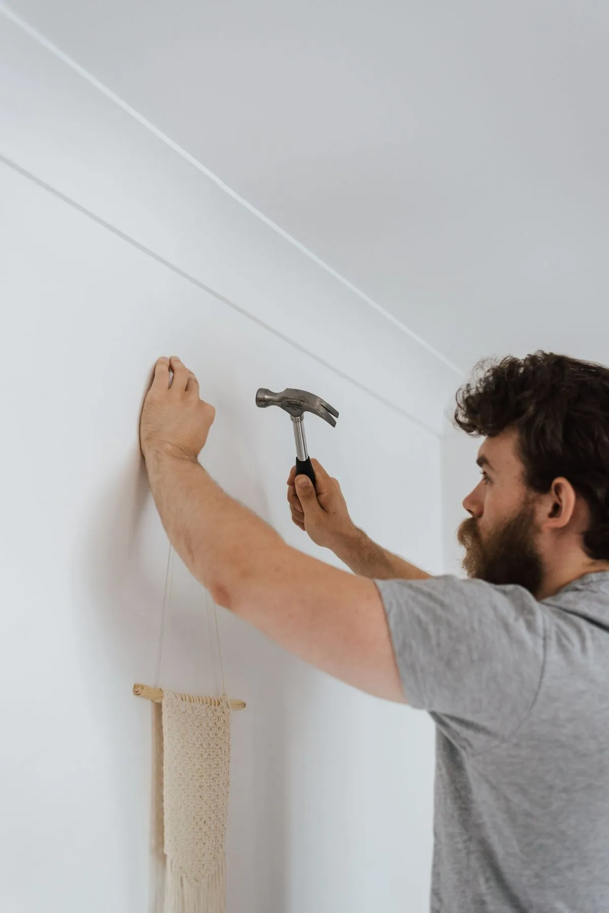 Artisan qui fixe un clou dans un mur fraîchement enduit
