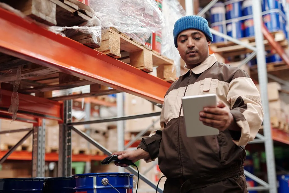 Magasinier qui contrôle le stock de matériaux sur tablette