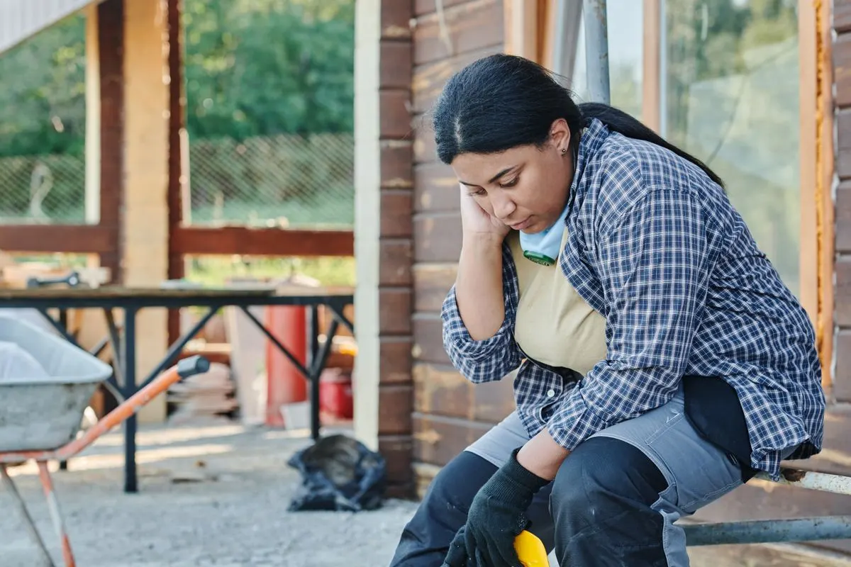 Artisane fatiguée assise sur son chantier