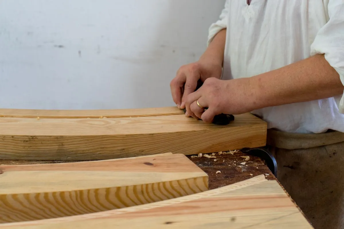 Charpentier qui assemble deux pièces de bois
