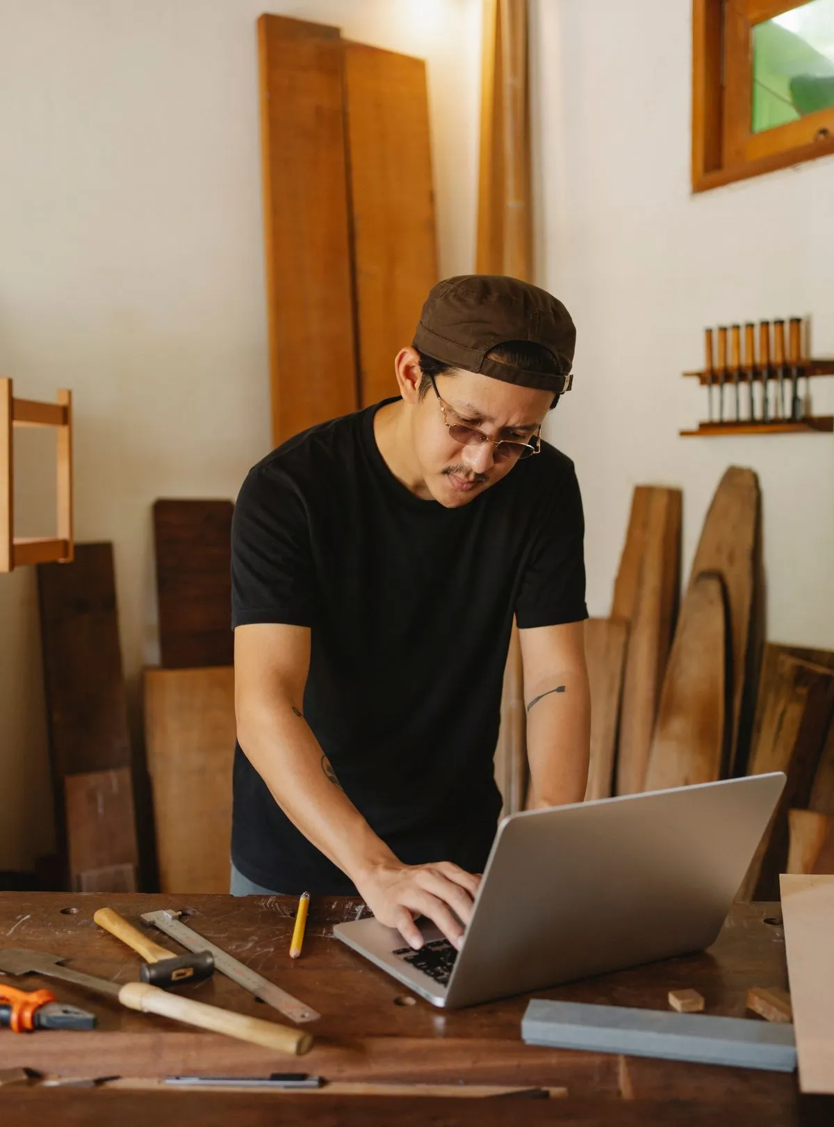 Artisan qui prépare un devis sur son ordinateur portable dans son atelier