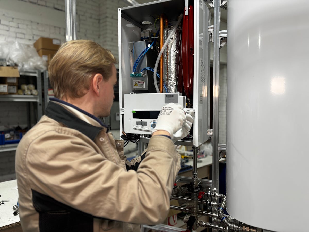 Technicien chauffagiste réparant un système de chauffage en atelier — logiciel BatUp pour entreprise de chauffage