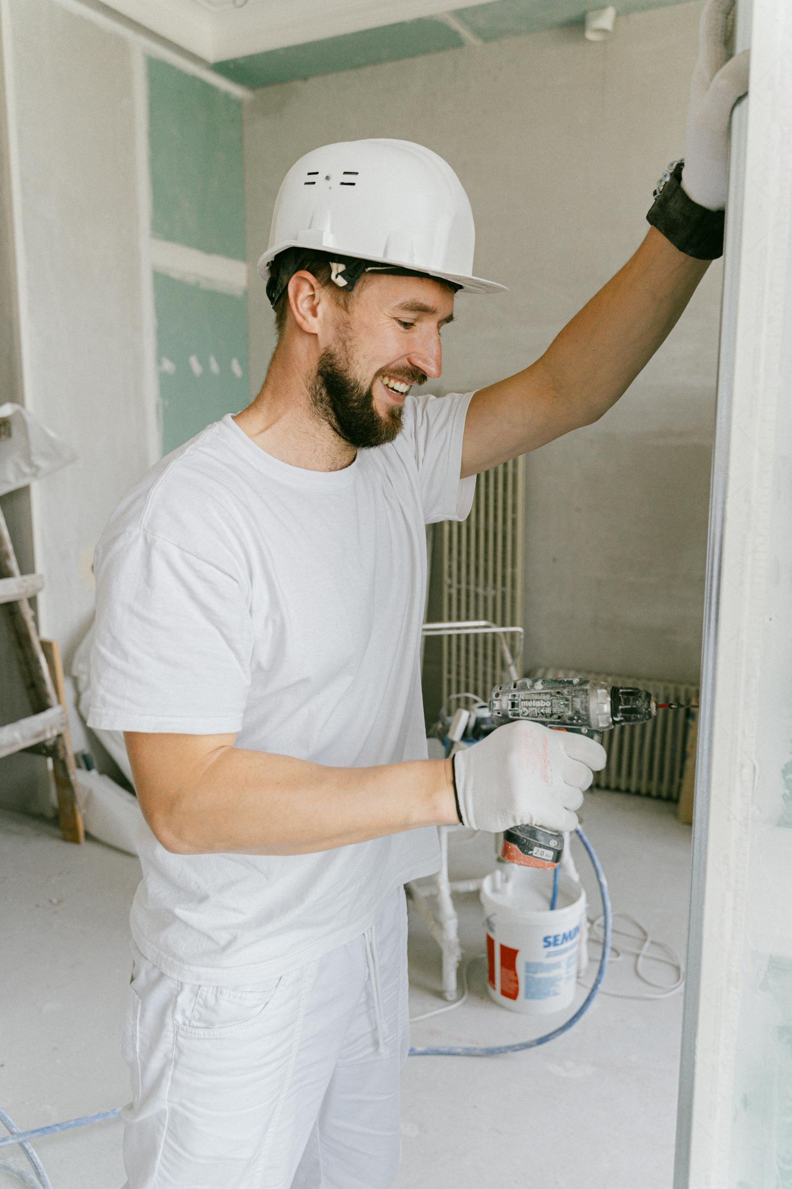 Peintre en bâtiment appliquant une couche au rouleau — logiciel BatUp pour entreprise de peinture